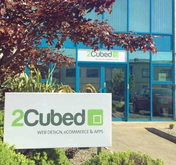 2Cubed Web Design outside of building with sign post in front. Where to get your Web Design Quote.